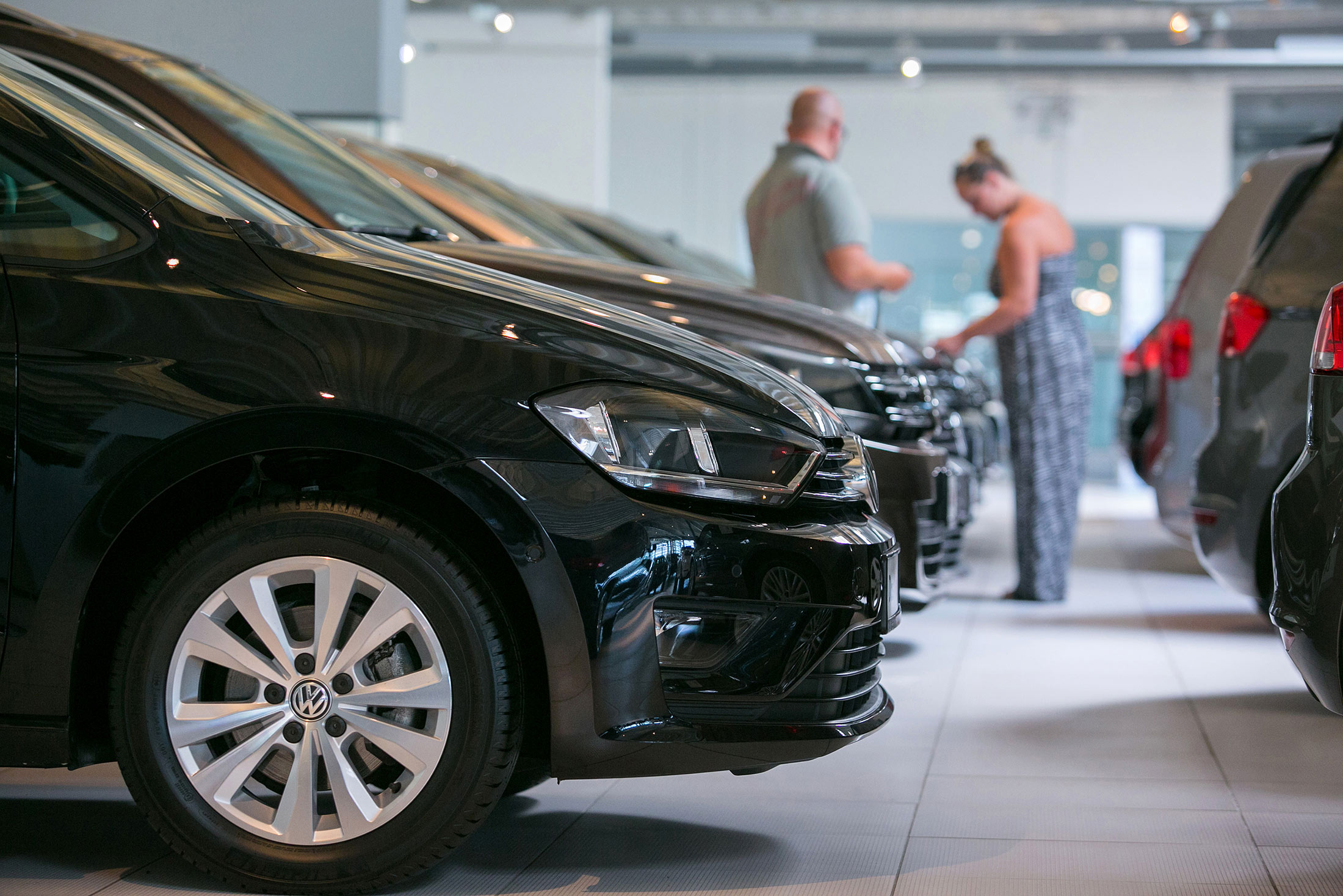 Customers browse used cars inside the Volkswagen AG automobile showroom in Berlin, Germany, on Aug. 6, 2015.
