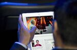 An attendee reads a Los Angeles Times newspaper article using the Flipboard app on an iPad.
