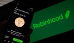 This photo illustration shows a person looking at a smartphone with the projected Robinhood price shares.