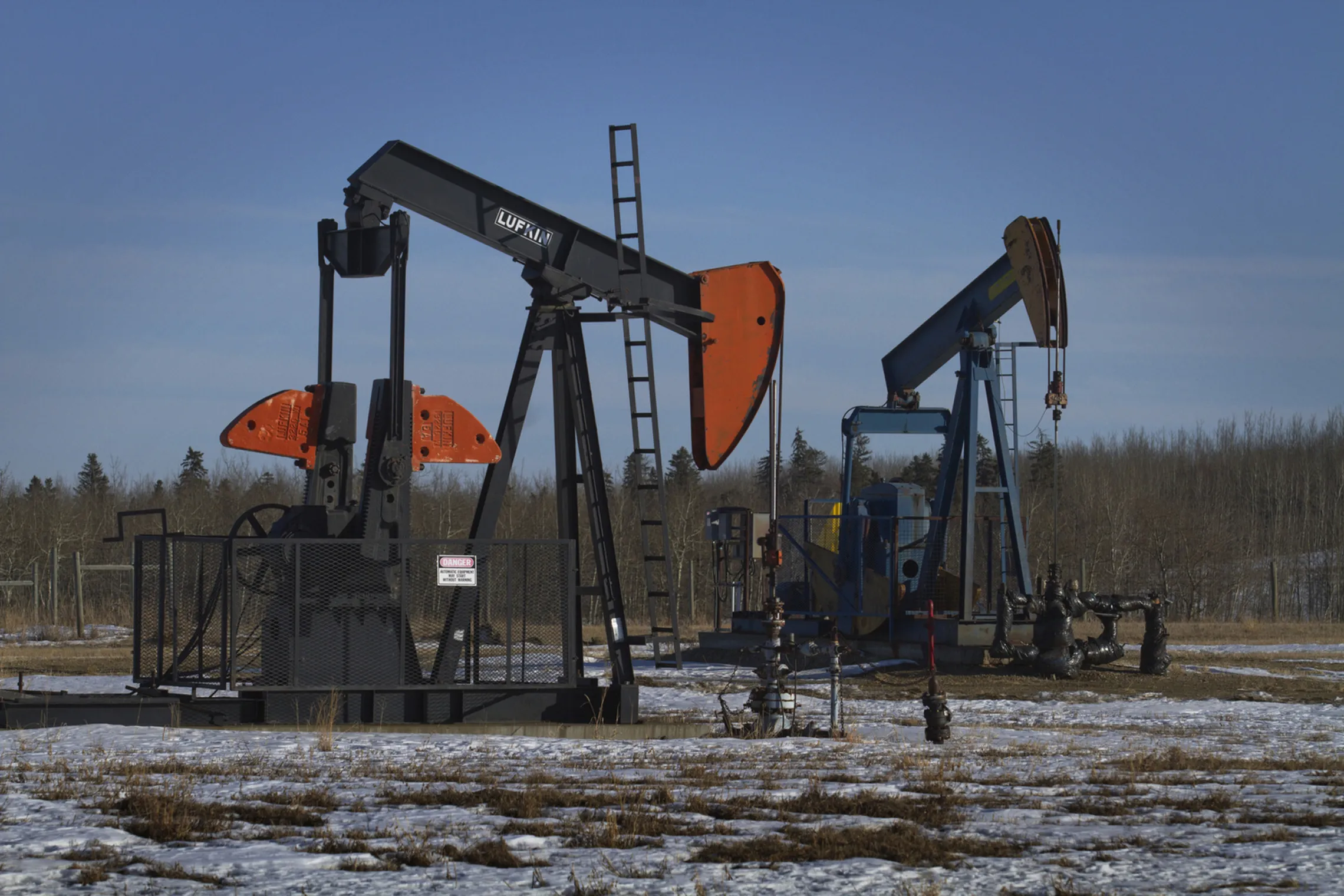 A pair of pumpjacks in an&nbsp;oil field near Pigeon Lake, Alberta.