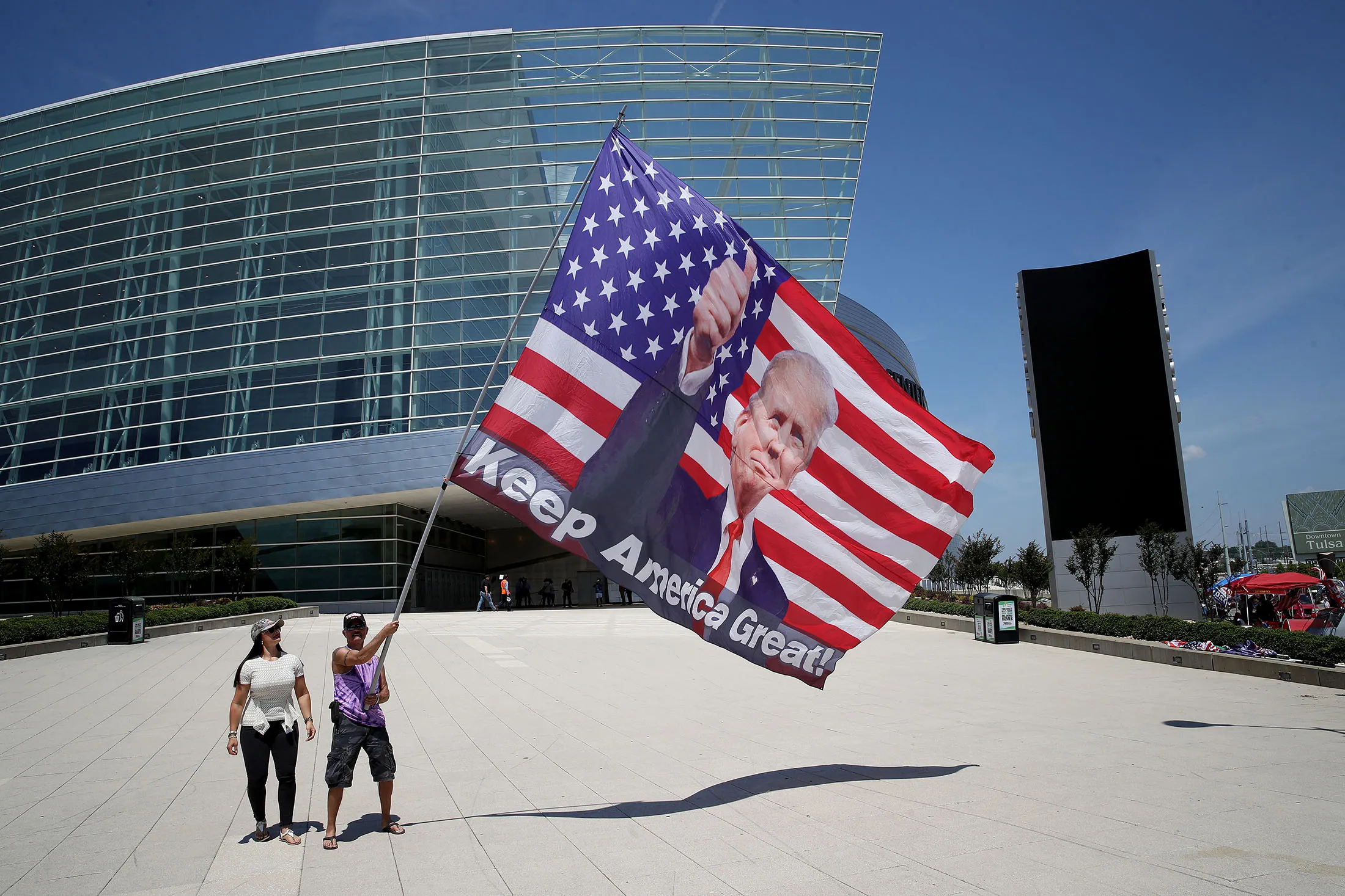 Trump supporters pose for photos with a giant Trump flag outside BOK Center in Tulsa, Oklahoma, on&nbsp;June 18.