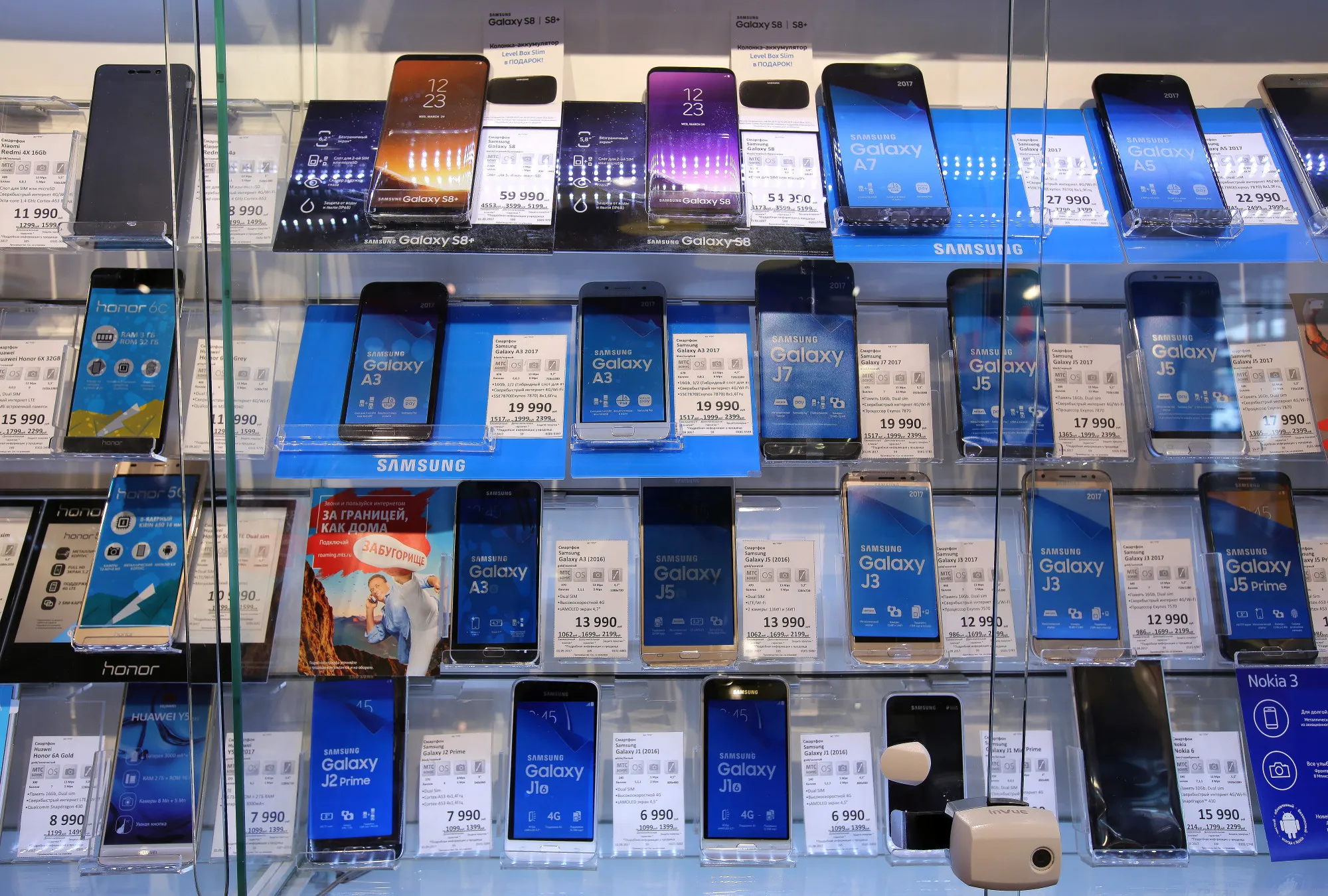 A collection of Samsung Electronics Co. Galaxy smartphones sit in a display cabinet beside prices and specification information inside a Mobile TeleSystems PJSC (MTS) mobile communications store in Moscow, Russia, on Friday, Sept. 1, 2017. Billionaire Vladimir Evtushenkov’s Sistema PJSFC may have to reduce its stake in Russia’s largest wireless carrier, Mobile TeleSystems PJSC, to help pay a $2.3 billion court damages bill, according to investment analysts.