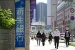 Pedestrians wearing protective masks in front of the Shinsei Bank Ltd. headquarters in Tokyo, Japan,