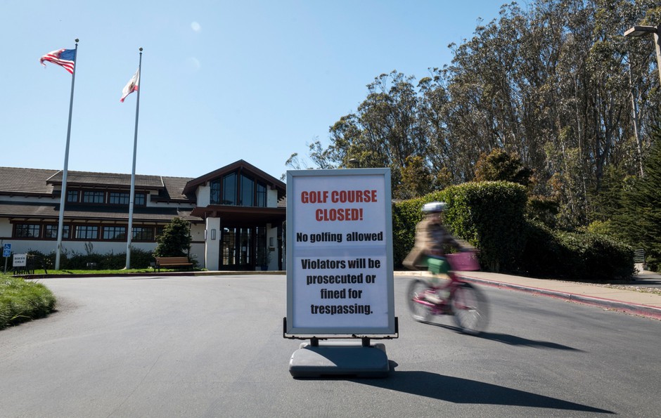 A cyclist rides past a closure sign at an entrance to the Presidio Golf Course in San Francisco. Public golf courses should be opened up to other uses during the pandemic, many have argued.