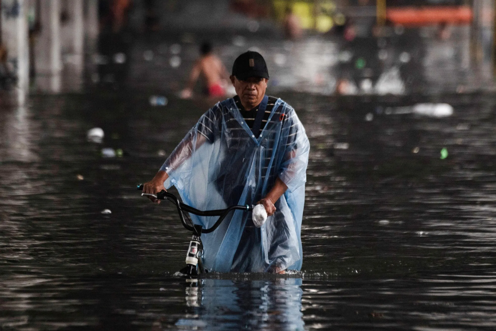 A man wades through a flooded street after heavy rains in Manila&nbsp;in July.&nbsp;