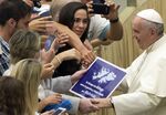 A placard which reads, &quot;It's time for dialogue between Argentina and the United Kingdom for Falklands&quot;, is held by audience members as Pope Francis is greeted during the weekly general audience in the Paul VI hall at the Vatican, on Aug. 19.
