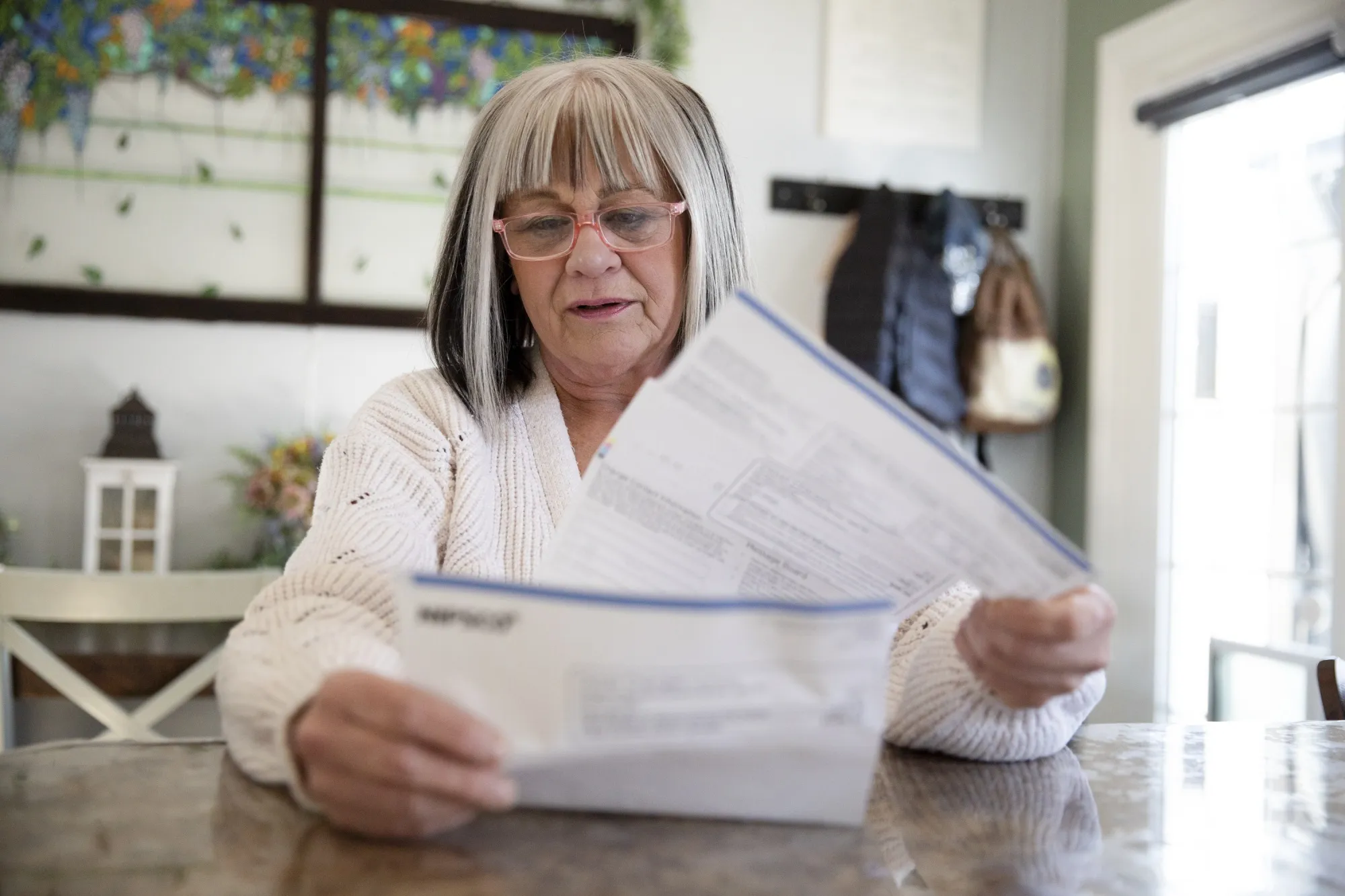 Mary Dres looks at her electricity bills in her home