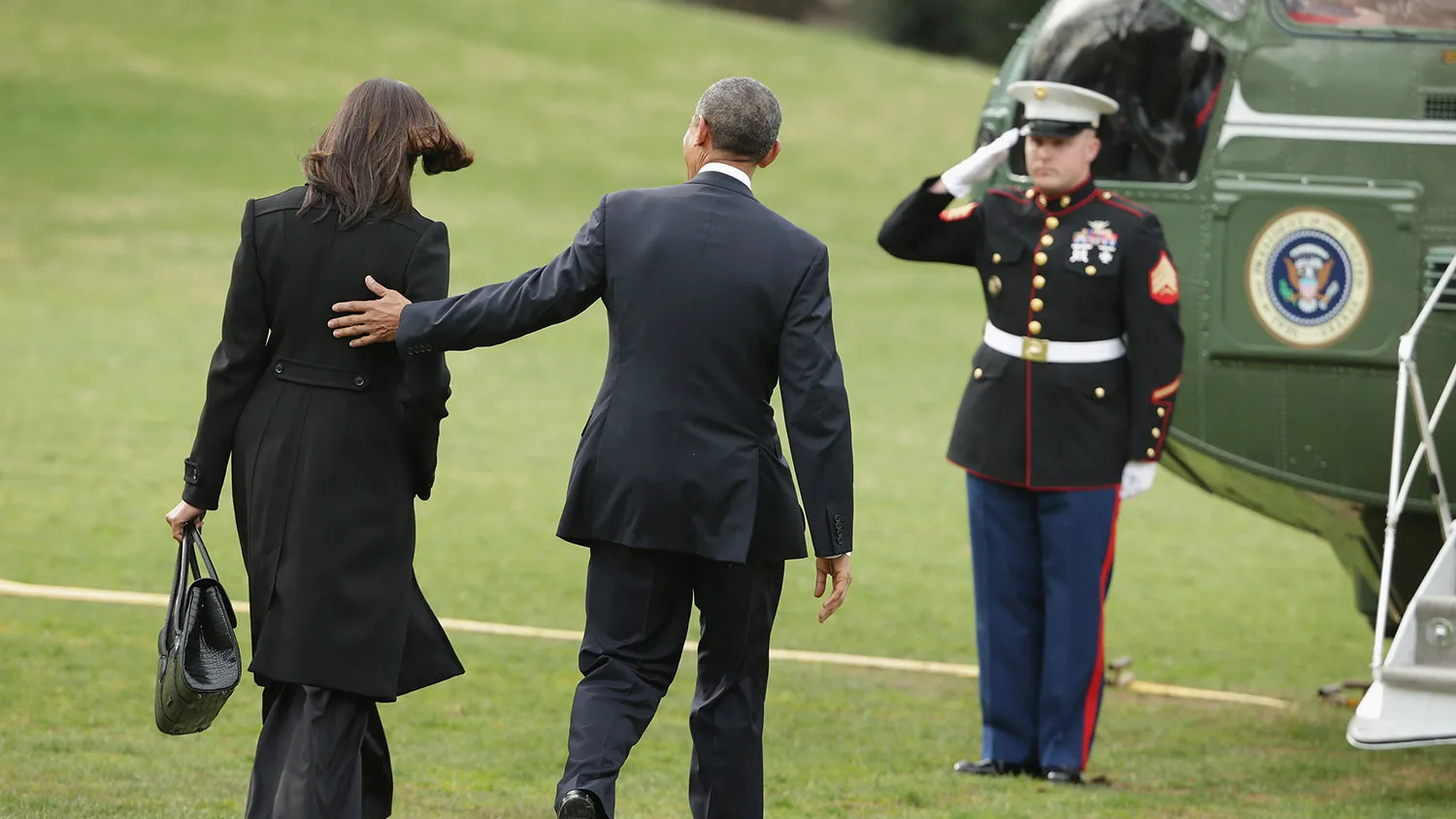 U.S. President Barack Obama (C) and first lady Michelle Obama (L) walk across the South Lawn before boarding Marine One and departing the White House March 30, 2015 in Washington, DC.
