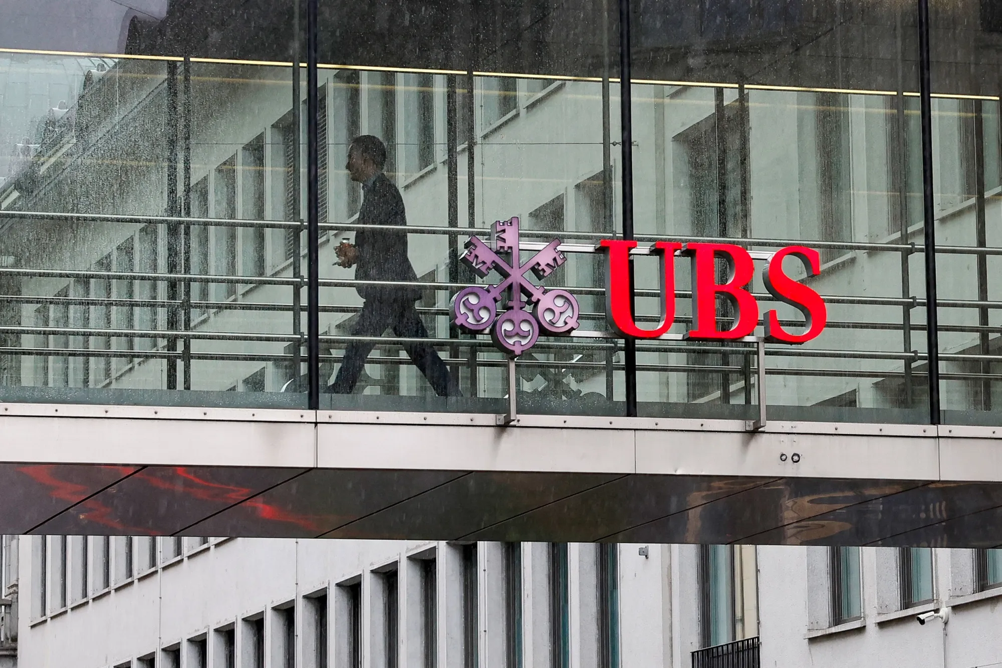 A worker uses a pedestrian overpass between offices at the UBS Group headquarters in Zurich.