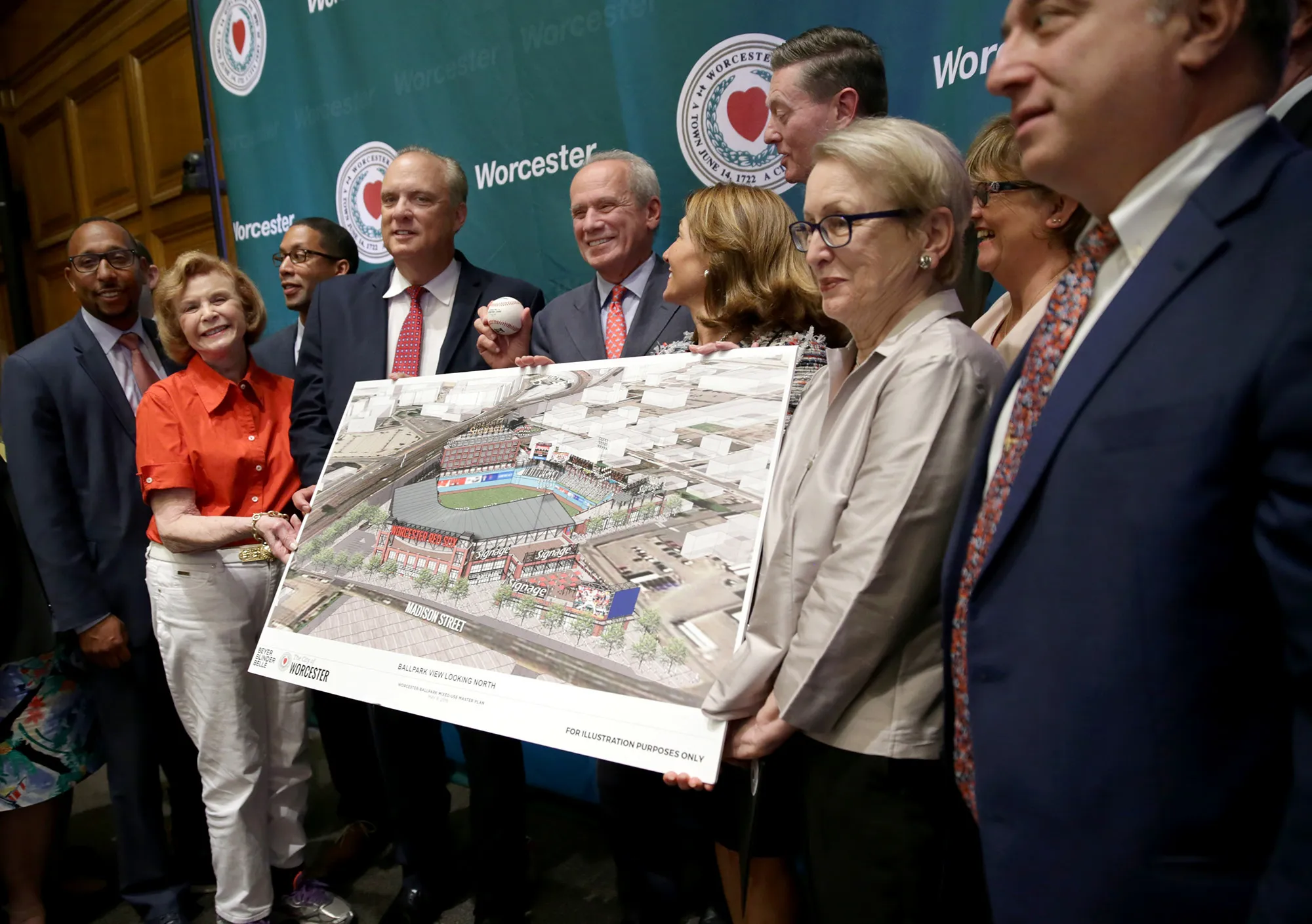 The Pawtucket Red Sox’s Larry Lucchino, holding baseball, in 2018, announcing minor league team’s move to Worcester.