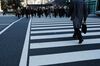 Morning commuters cross a road in front of Tokyo Station in Tokyo.
