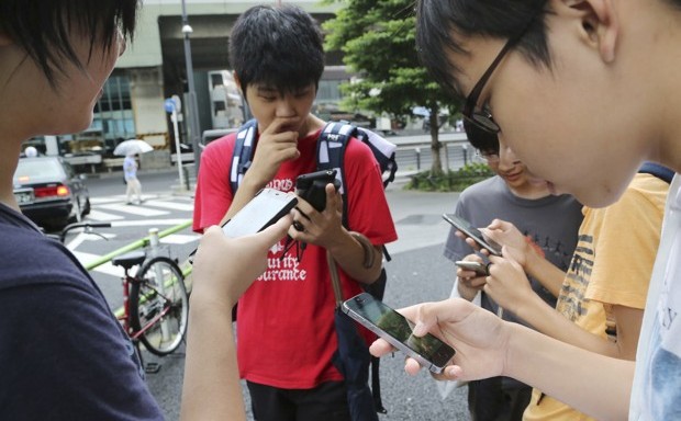 Japanese students play &quot;Pokemon Go&quot; in the street as its released in Tokyo.