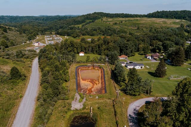 Hills made of waste at the shuttered Martinka coal mine generate rust-colored runoff