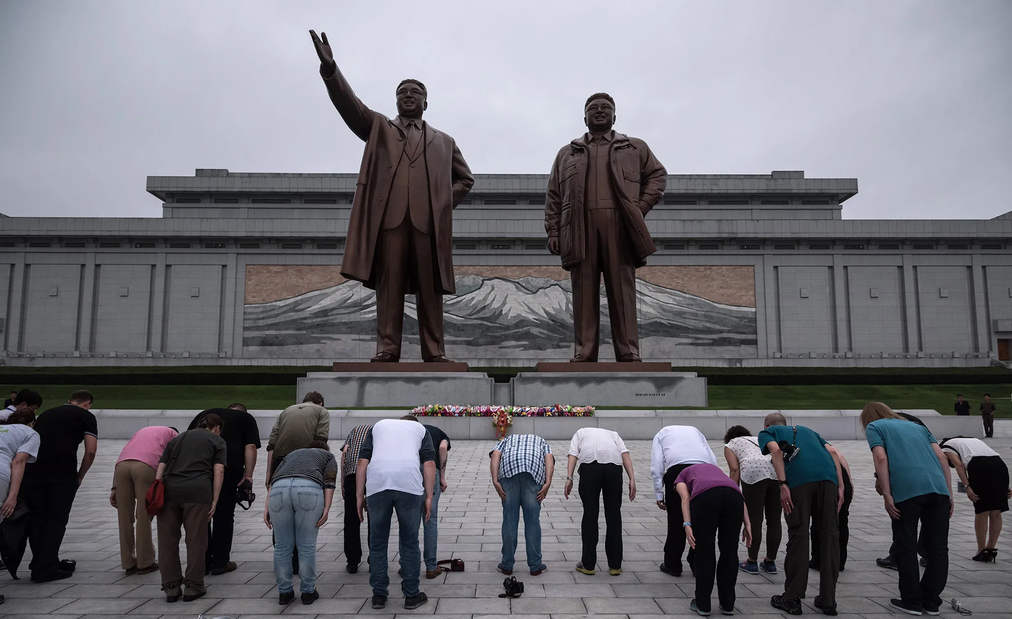 People bow before statues of late North Korean leaders Kim Il-Sung and Kim Jong-Il on Mansu hill in Pyongyang.