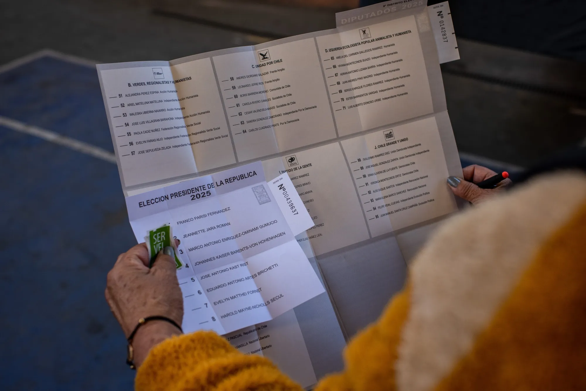 A voter reads ballots at a polling station in Santiago, on Nov. 16. 