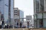 People wearing protective masks queue outside a bank as they wait to withdraw money from an ATM machine in Beirut.