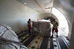 Workers load a cargo pallet onto a cargo jet at Miami International Airport in Miami, Florida.