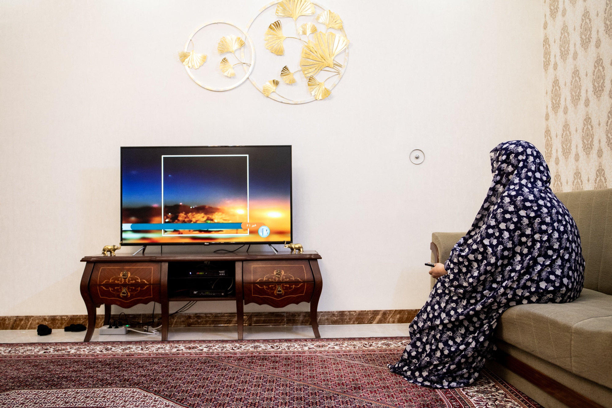 A woman watches a news TV channel in Tabriz, Iran after 'massive explosions' in central Isfahan province on April 19.