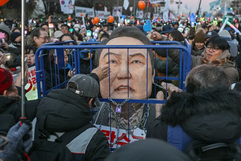 A protester hits an effigy of Yoon Suk Yeol during a demonstration in Seoul on Dec. 14.
