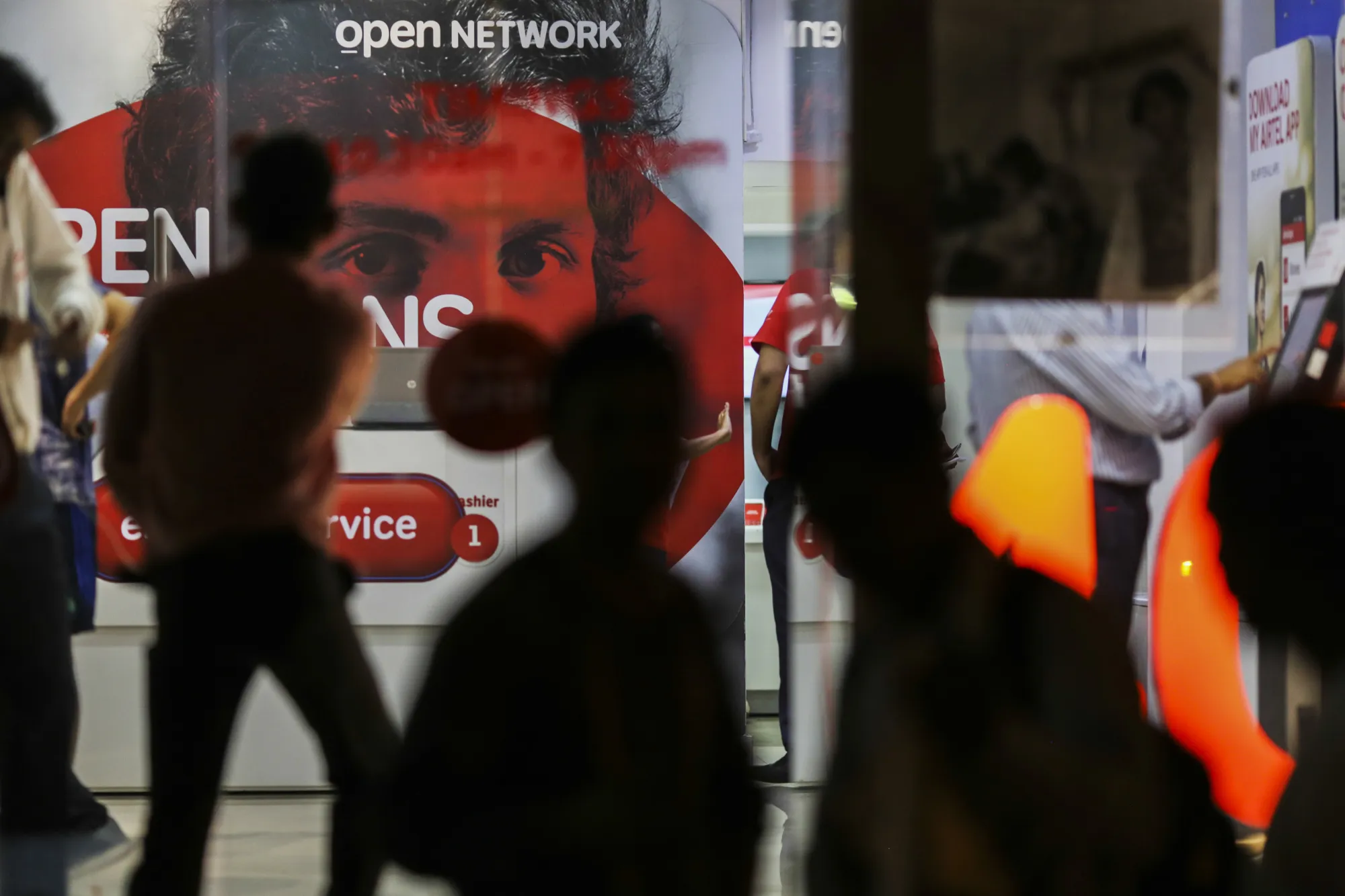 Pedestrians walk past a Bharti Airtel Ltd. store in Mumbai, India, on Monday, Oct. 24, 2016.