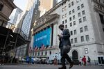 A pedestrian wearing a protective mask passes in front of the New York Stock Exchange (NYSE) in New York, U.S., on Thursday, July 22, 2021. After a year of Zoom meetings and awkward virtual happy hours, New York's youngest aspiring financiers have returned to the offices of the city's investment banks, where they're making the most of the in-person mentoring and networking they've lacked during the pandemic.