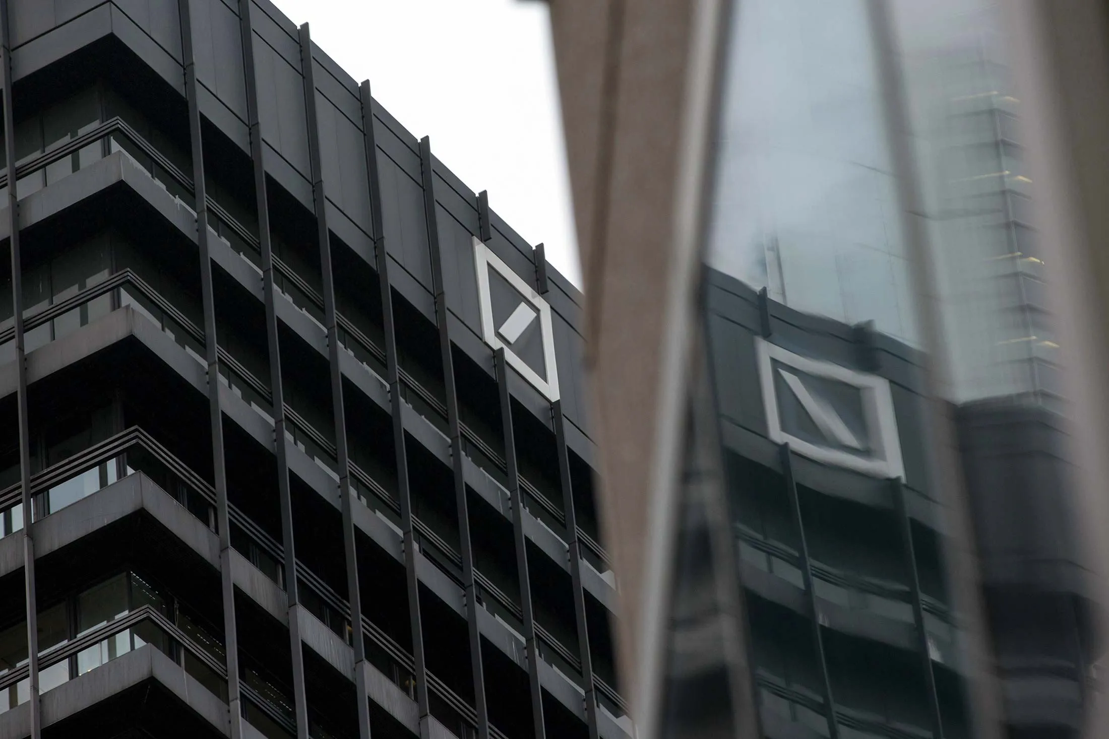 The Deutsche Bank AG logo sits on the German lenders office building in Frankfurt, Germany, on Thursday, Oct. 20, 2016. Unlike Deutsche Bank, which announced plans in June to reduce its branches to 535 from 723 next year, Commerzbank says its branch network is key to its strategy to add two million new clients by 2020, double its previous target.
