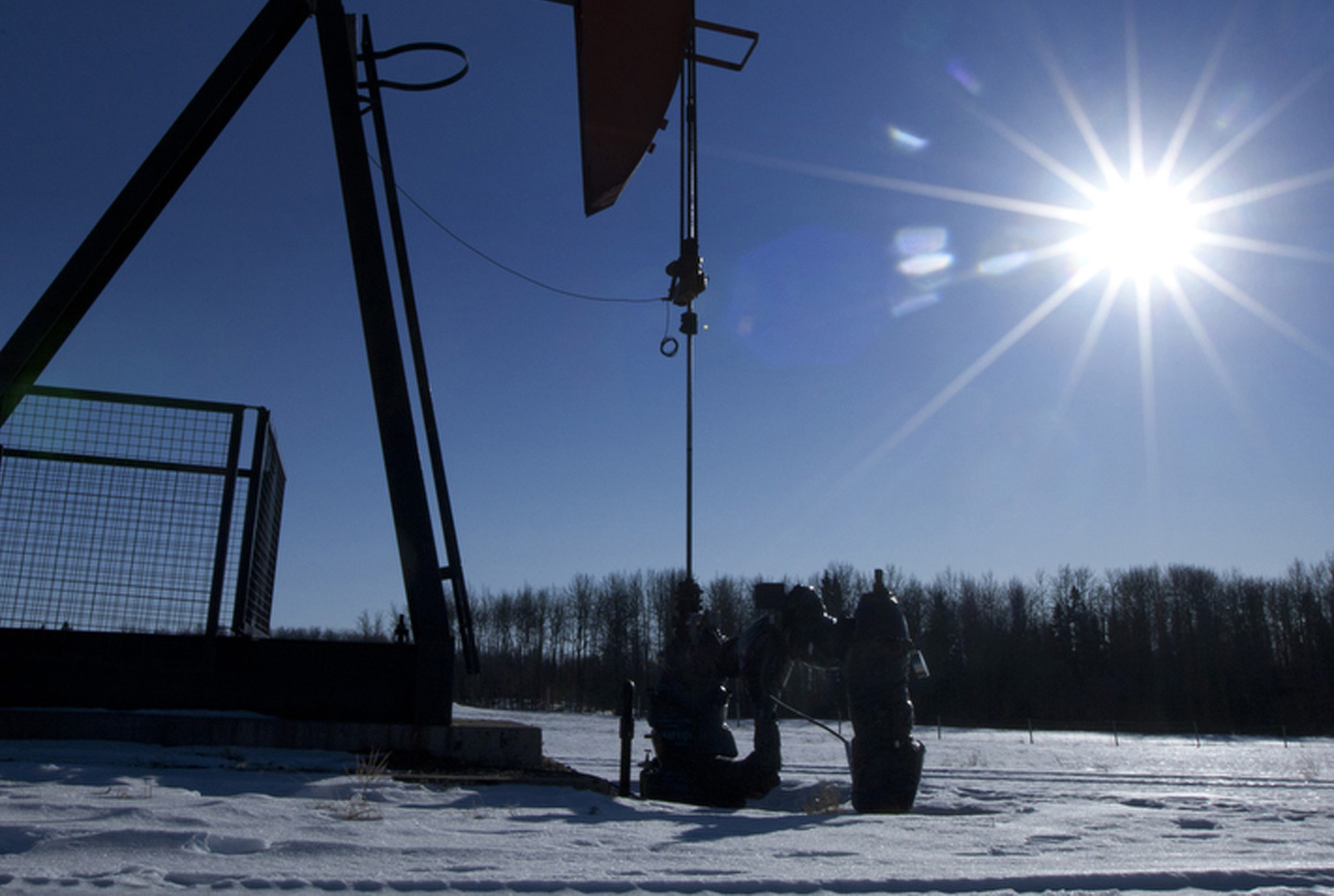 A pumpjack pumps oil from a well on a farmer's frozen field in a Pembina oil field near Pigeon Lake, Alberta, Canada on Friday, Feb. 17, 2012. The Pembina oil field is one of the largest oil fields in the province of Alberta.
