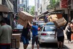 Delivery workers carry boxes in Ciudad del Este, Paraguay, on Saturday, Dec. 2, 2023. Paraguay's central bank accelerated the pace of monetary easing at its last monthly policy meeting, delivering a surprise half-percentage point cut to drop the benchmark interest rate to 7.25%.