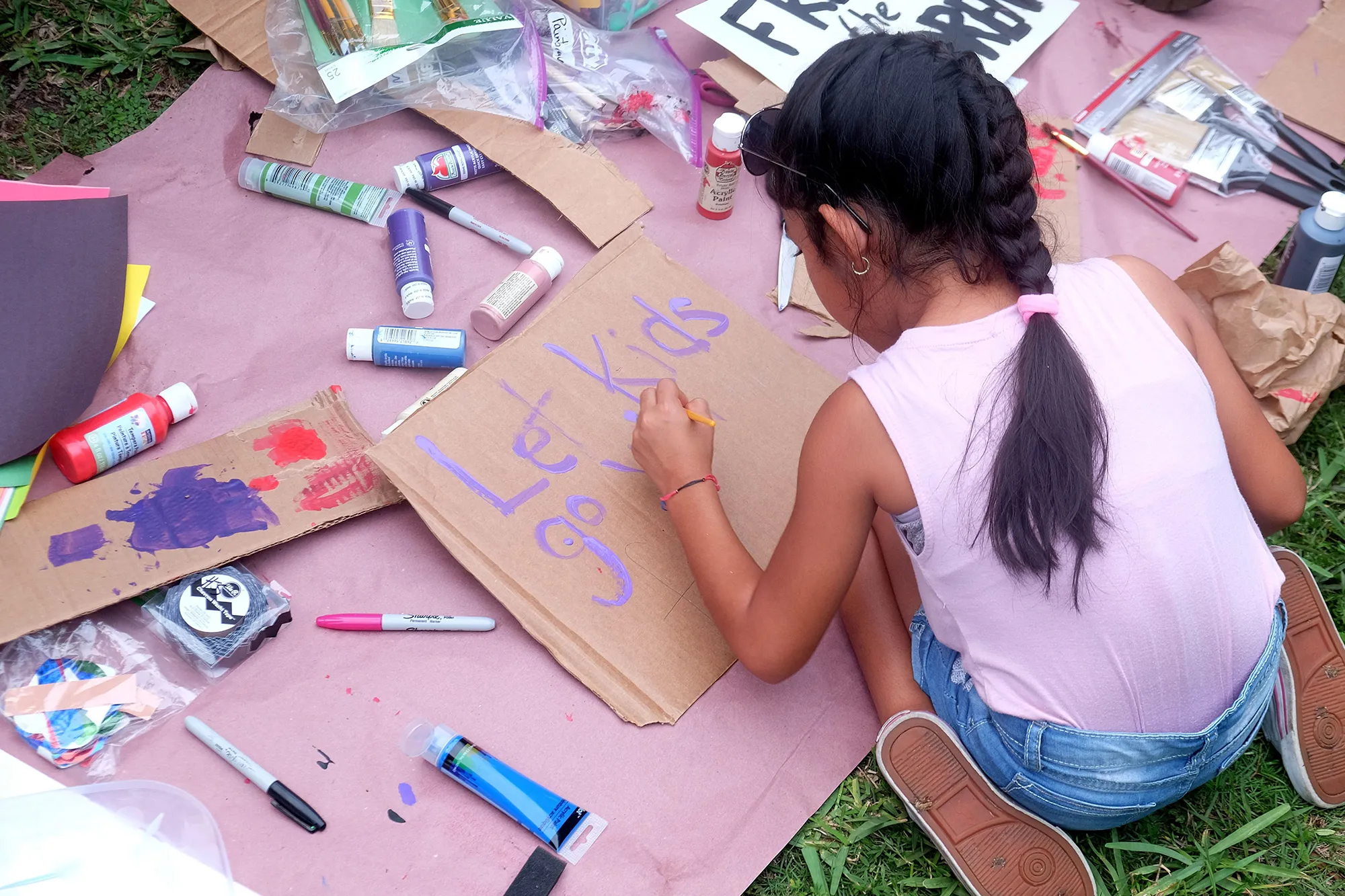 A child paints a sign during a&nbsp;protest rally outside the Homestead Temporary Shelter for Unaccompanied Children, in&nbsp;Florida.&nbsp;