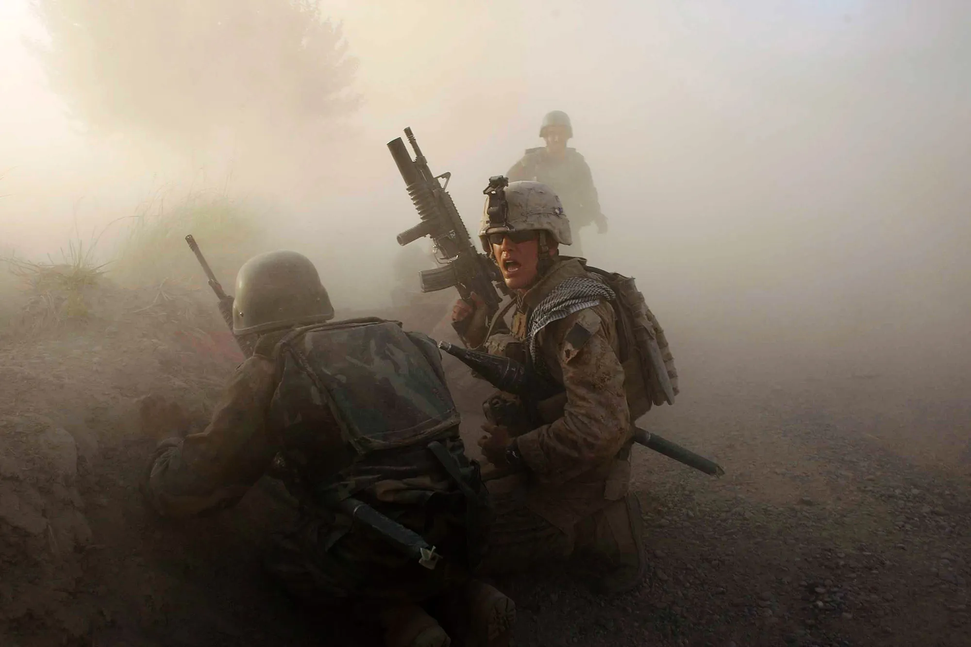 A U.S. Marine along with an Afghan soldier after an IED exploded while under enemy fire in Mian Poshteh, Afghanistan.