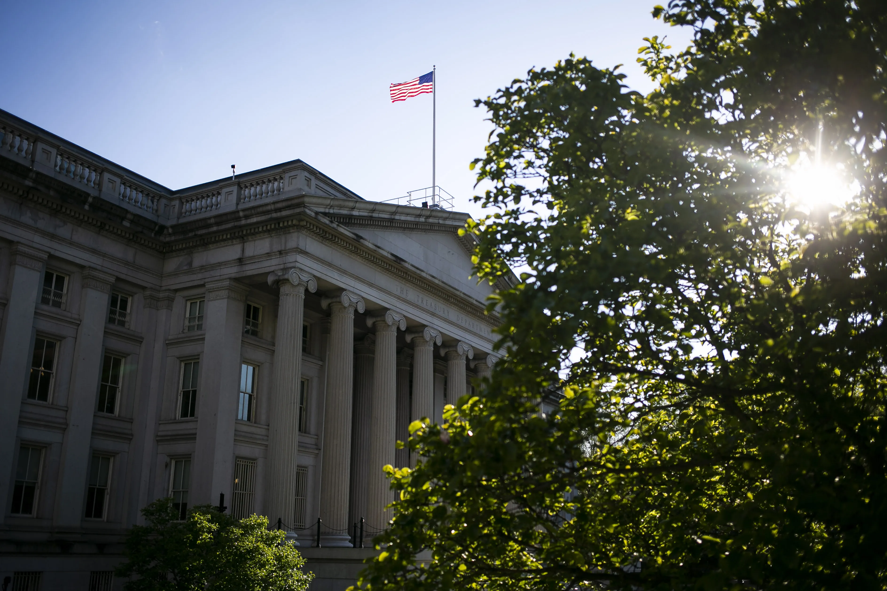 An American flag flies above the U.S. Treasury building in Washington, D.C.