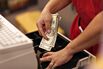 A cashier puts cash into a register 