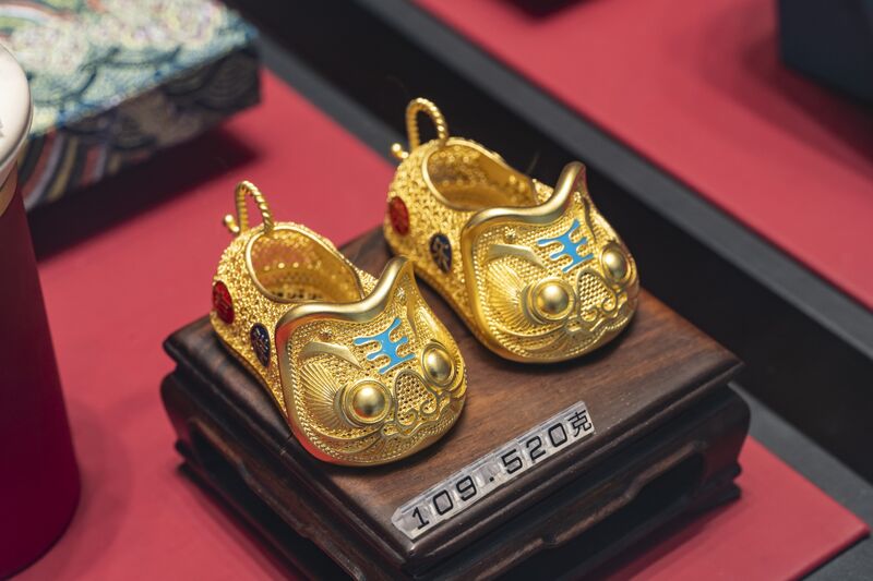 A pair of gold shoes for sale inside a Luk Fook Holdings International Ltd. jewelry store in Shanghai, China.