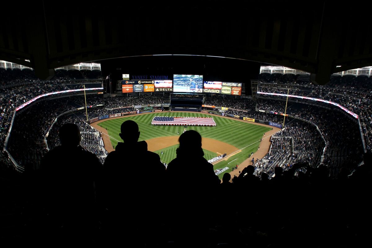 A giant United States flag is stretched across the outfield of