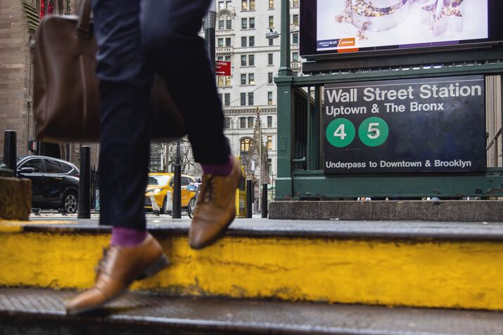 A commuter enters a Wall Street subway station.