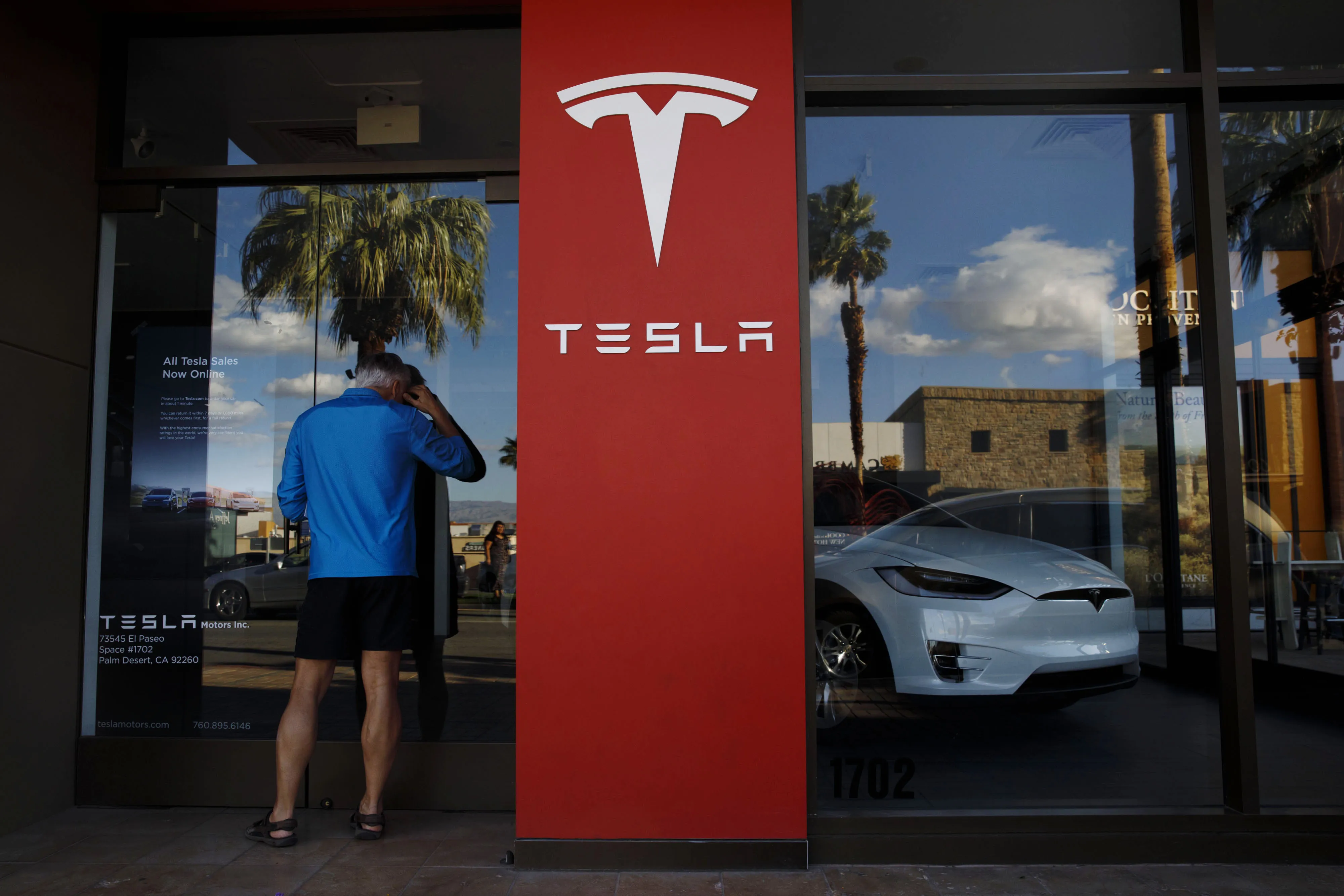 A pedestrian looks inside a Tesla Inc. store.