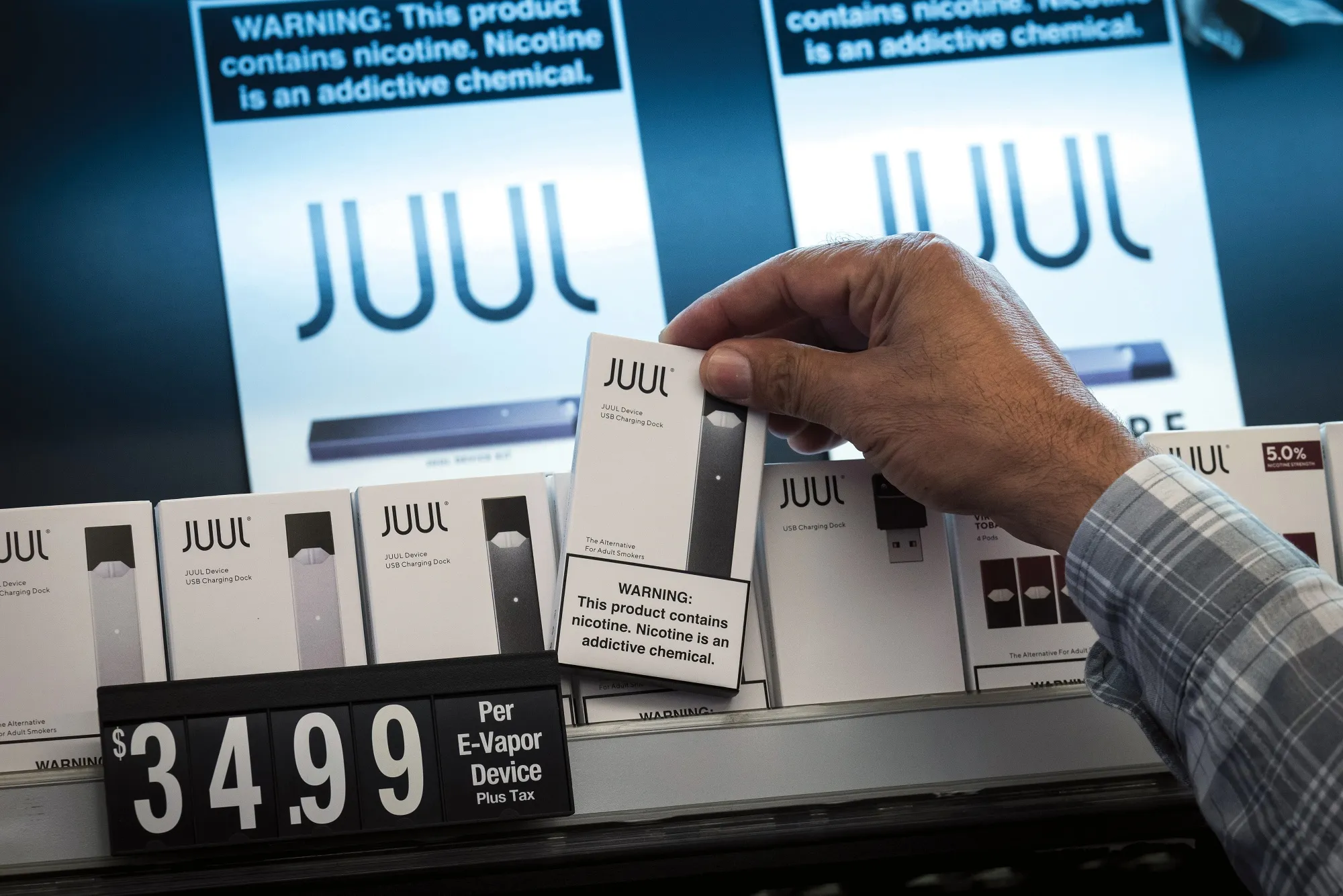 An employee picks up a Juul e-cigarette kit for a customer at a store in San Francisco, California.&nbsp;