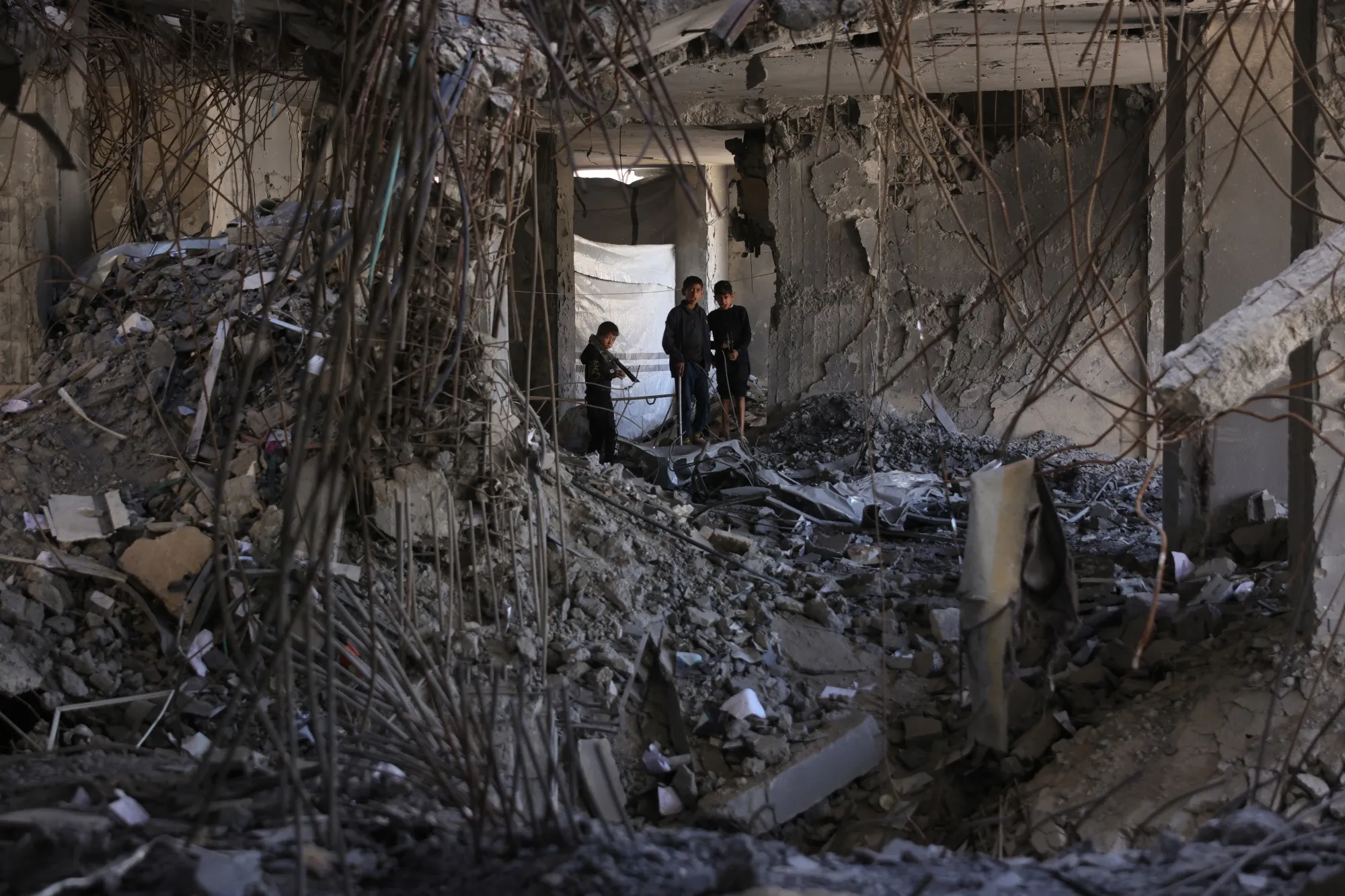 Displaced Palestinians walk through a damaged part of the&nbsp;Islamic University campus&nbsp; in Gaza City on April 16.
