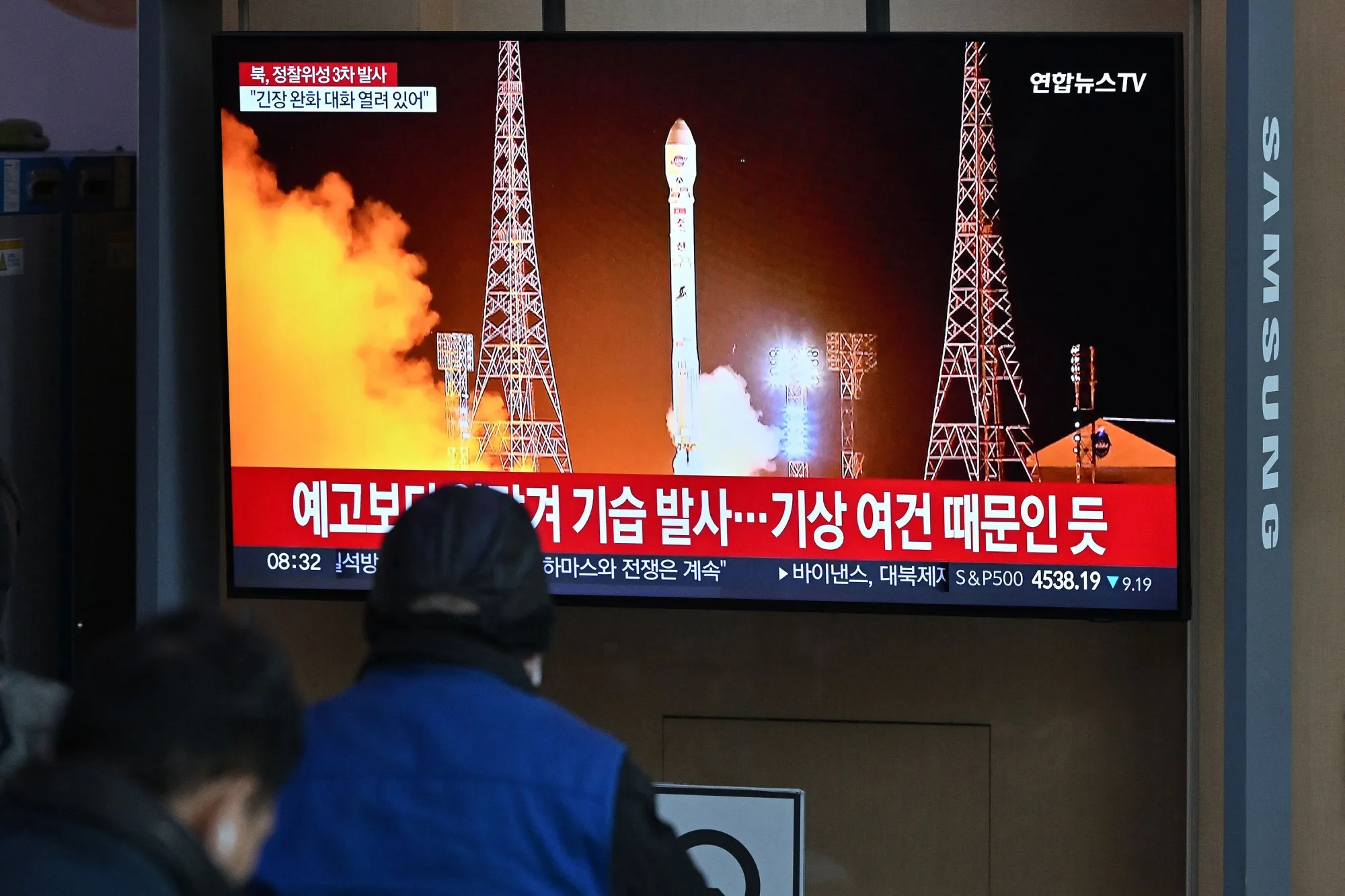 People watch a television screen showing a news broadcast with a picture of North Korea's latest satellite-carrying rocket launch,&nbsp;in Seoul, South Korea, on Nov. 22.