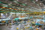 Employees assemble Boeing Co. 777 airplanes on a moving production line at the company's facility in Everett, Washington, on June 25, 2013