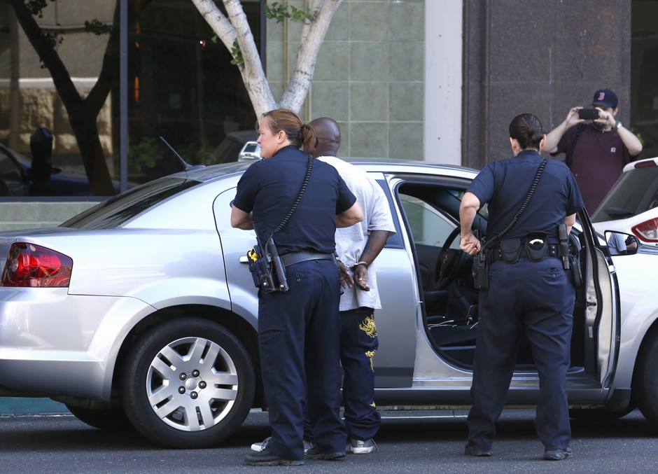 In this June 24, 2015 photo, a person at right records Sacramento Police officers taking a suspect into custody.