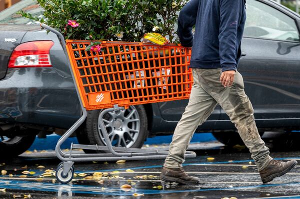 A customer pulls a shopping cart outside a Home Depot store in Palo Alto, California, US