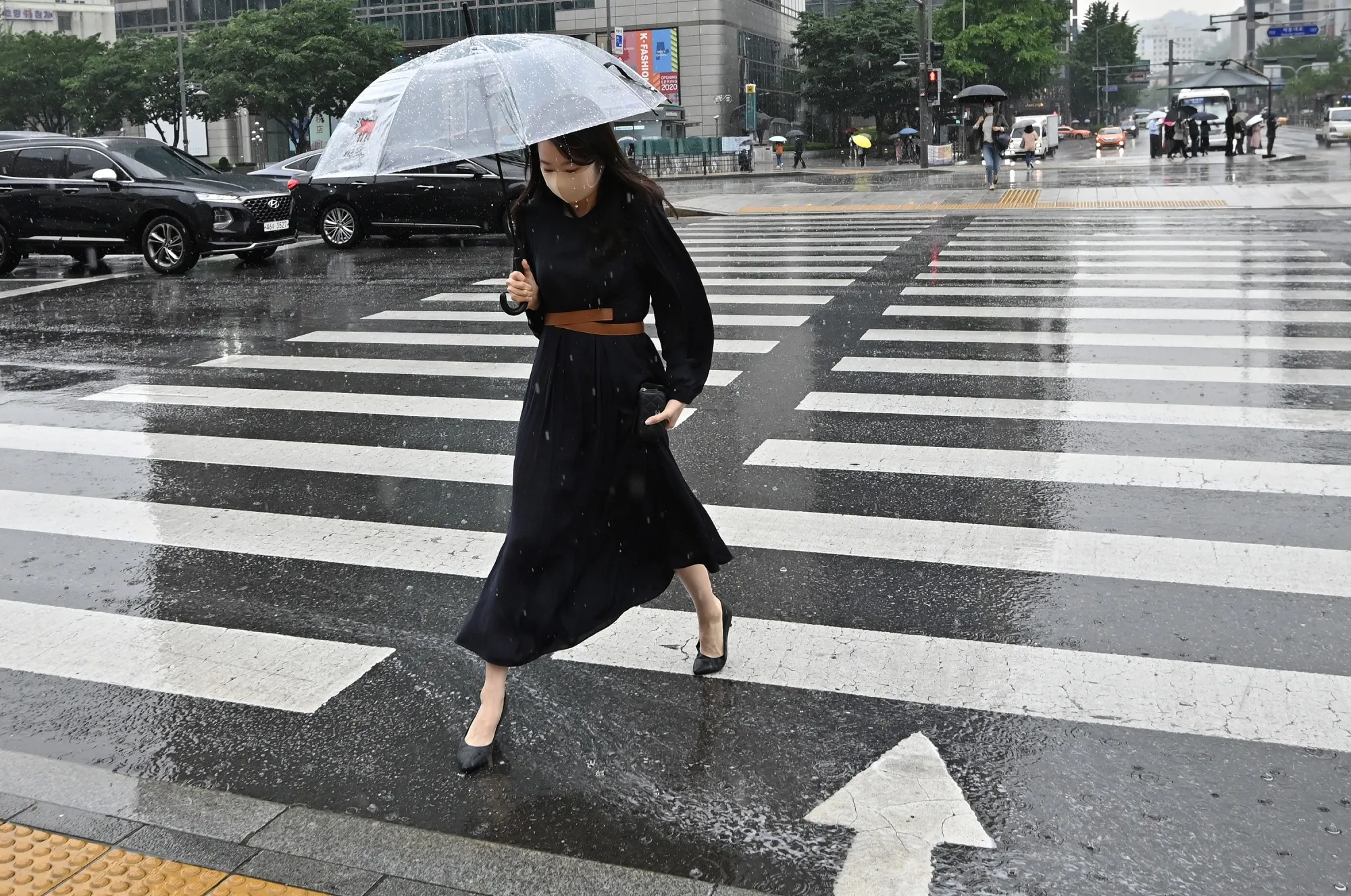 A woman holding an umbrella crosses a road in Seoul on June 2.