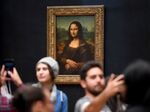 Visitors next to the Mona Lisa&nbsp;at the Louvre Museum in Paris.