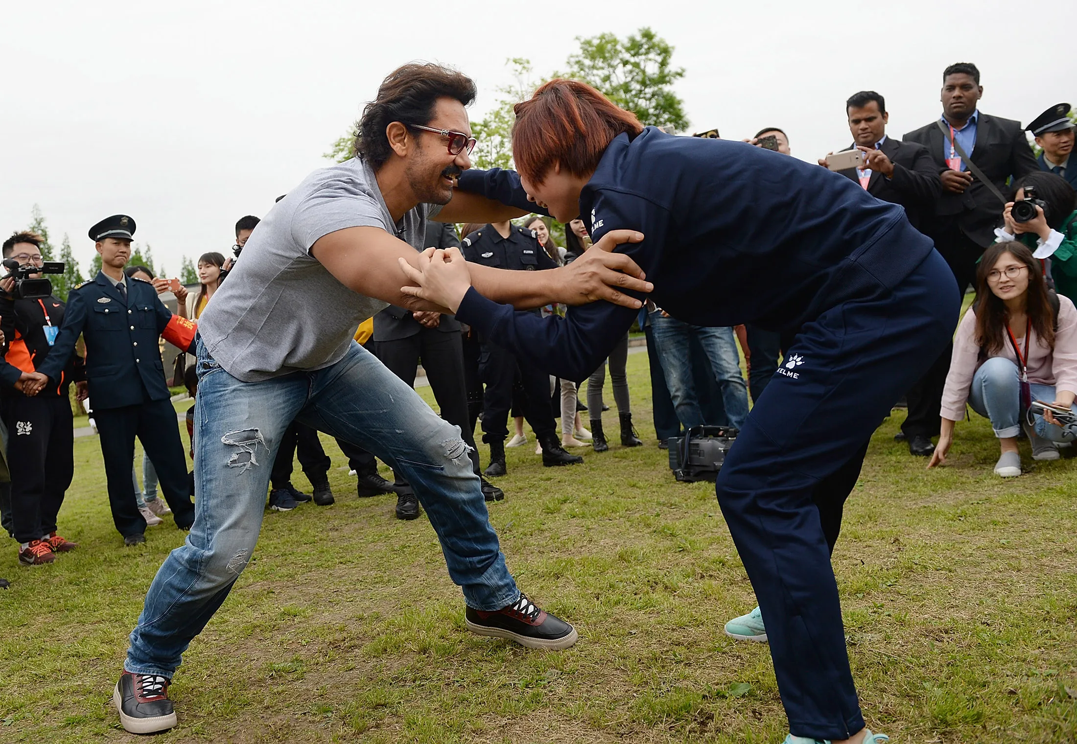 Bollywood actor Aamir Khan wrestles with a female wrestler at Mount Qingcheng in Chengdu.
