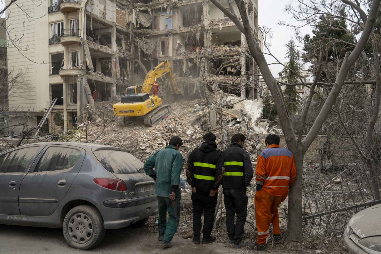 Rescue workers use&nbsp;heavy machinery to clear debris from a destroyed residential building in northern Tehran on March 23.