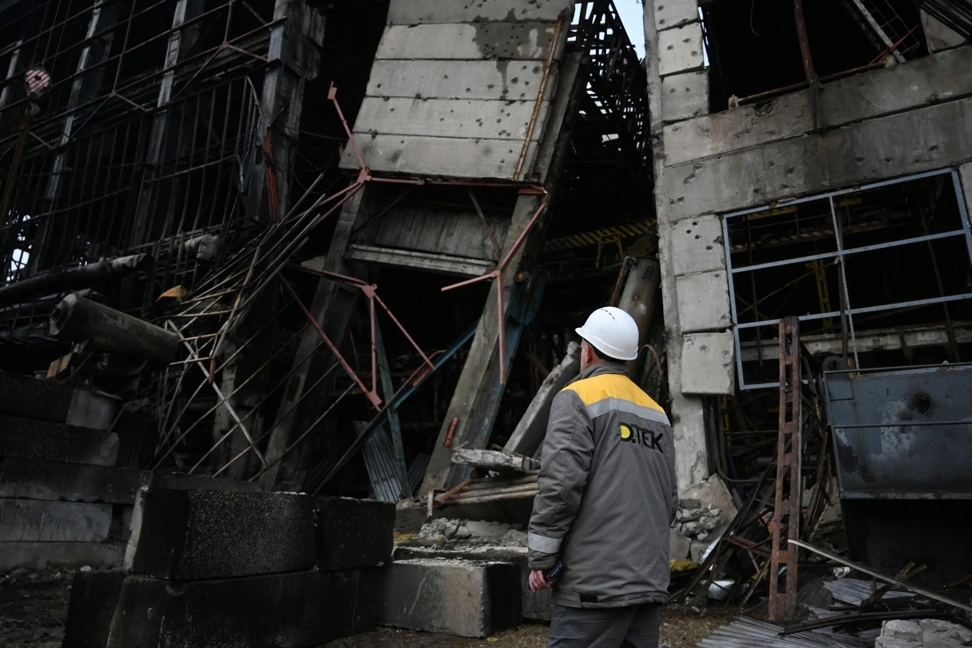 An employee stands next to a heavily damaged building of of Ukrainian energy provider DTEK power plant at an undisclosed location on Dec. 10.