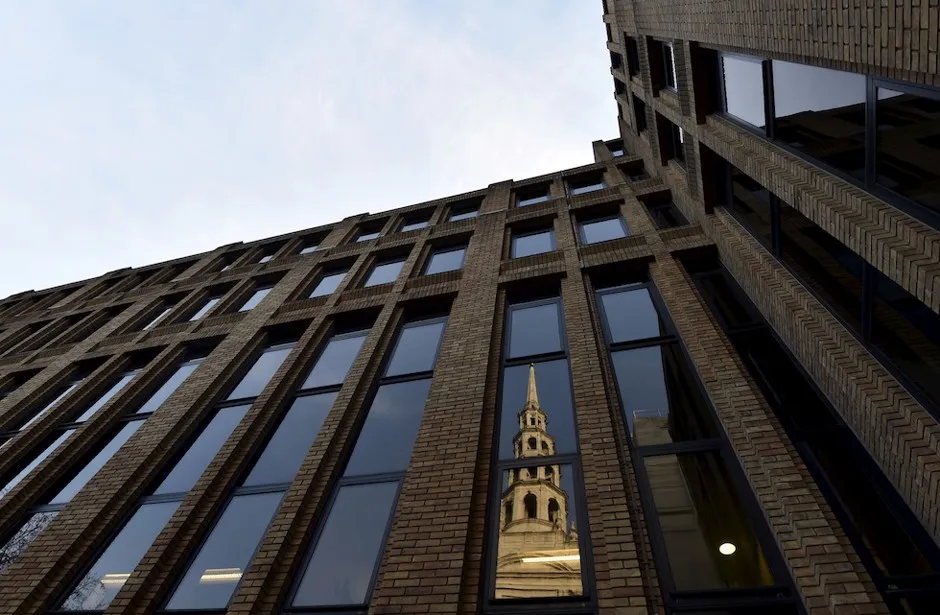 St. Bride's Church is reflected in an office window in the City of London.