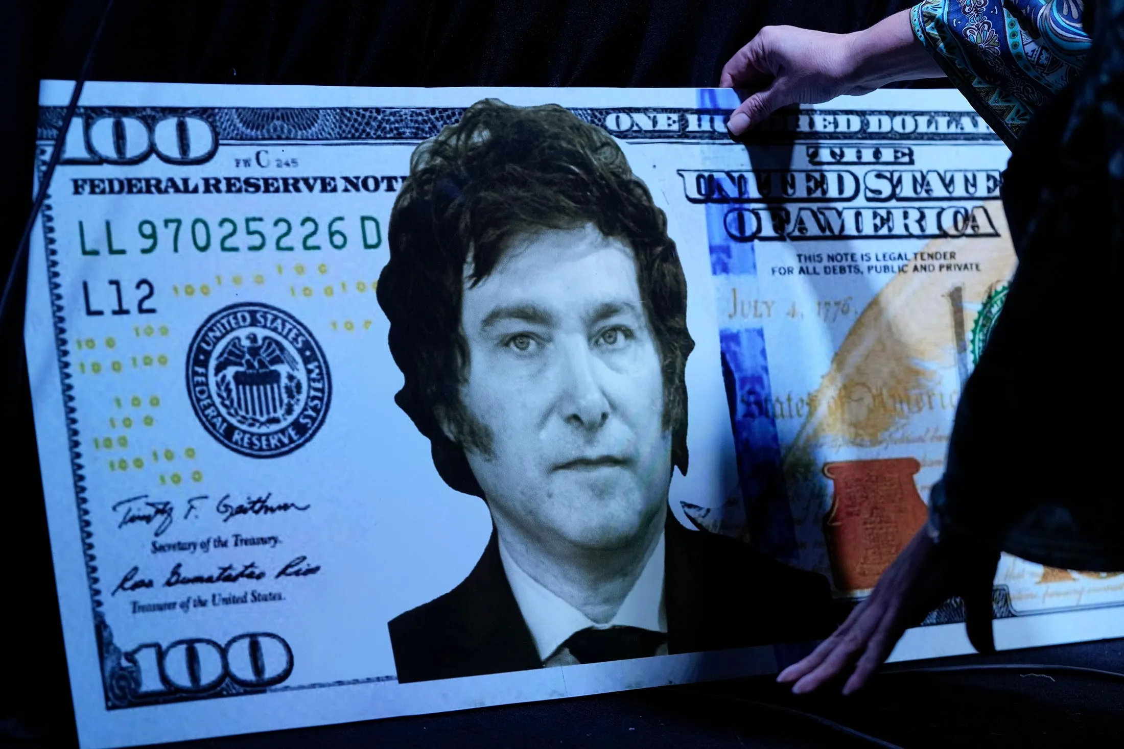 Un billete de cartón de $100 con la foto de Milei, utilizado como atrezo para una presentación del libro de Ocampo en la feria del libro de Buenos Aires el 14 de mayo.