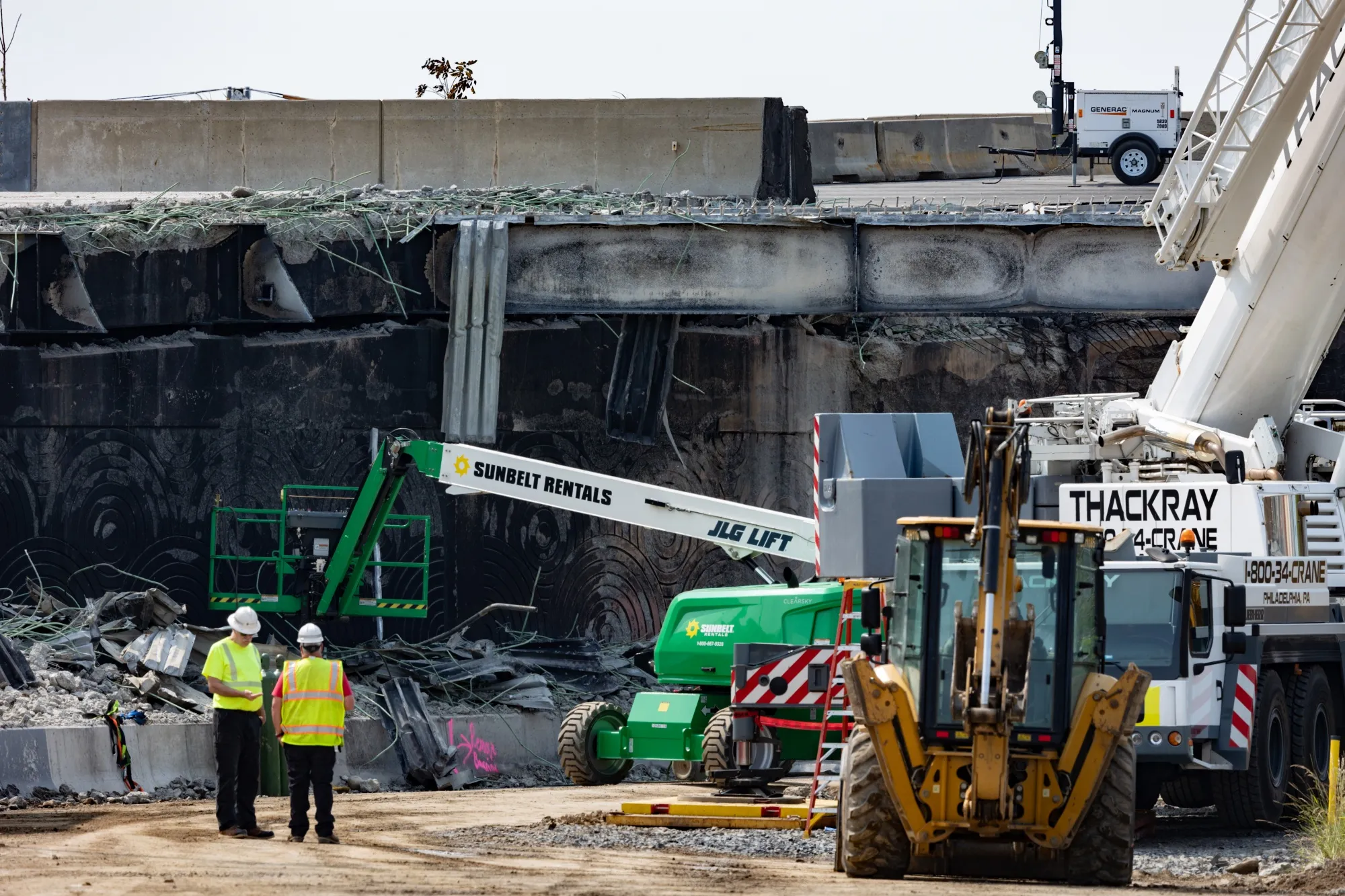 Workers clear debris from a section of the collapsed bridge in Philadelphia on June 15.